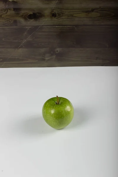 Una mela verde isolata su sfondo rustico. vista dall'alto — Foto Stock