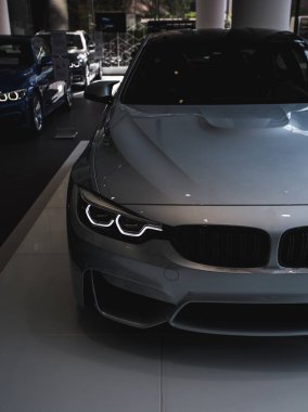 Sarı ışıklı gümüş renkli lüks bir sedan araba.