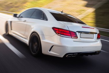 Test sürüşünde beyaz spor sedan, arkadan görüş