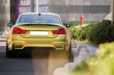 Çerçeveli altın renkli spor sedan araba.