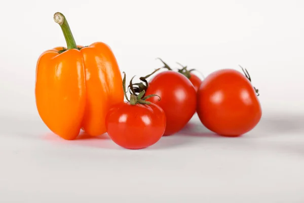 Tomates vermelhos e uma pimenta amarela — Fotografia de Stock