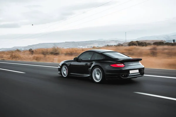 Siyah sedan otoyolda gidiyor.