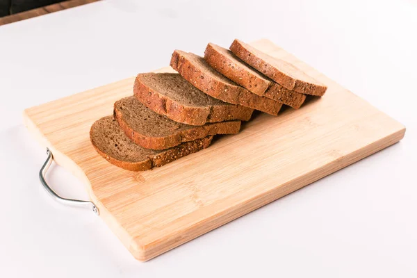 Thinly sliced dark wheat bread on a wooden board. top view — Stock Photo, Image
