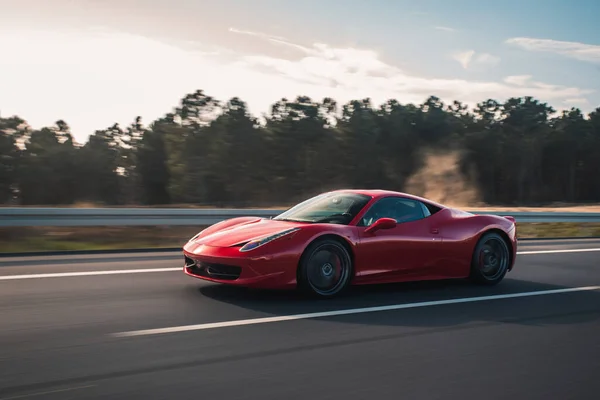 Kırmızı lüks spor sedan yolda.