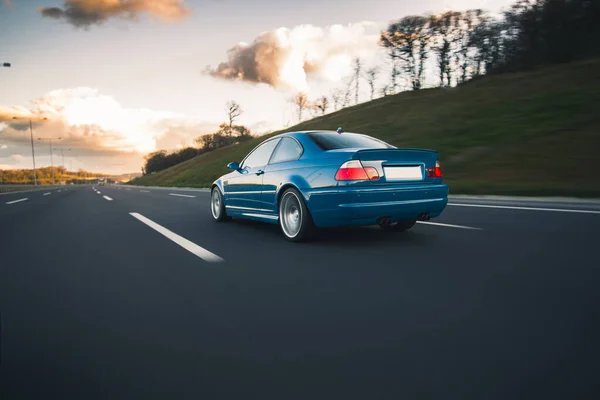 Kırmızı ksenon ışıklı mavi sedan.