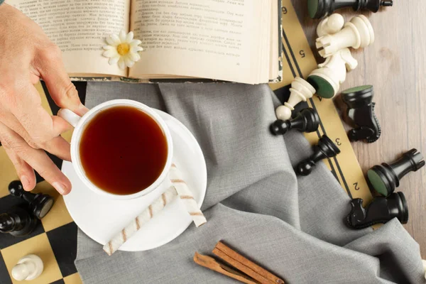 Eine Tasse Tee, ein Buch und Schachfiguren — Stockfoto