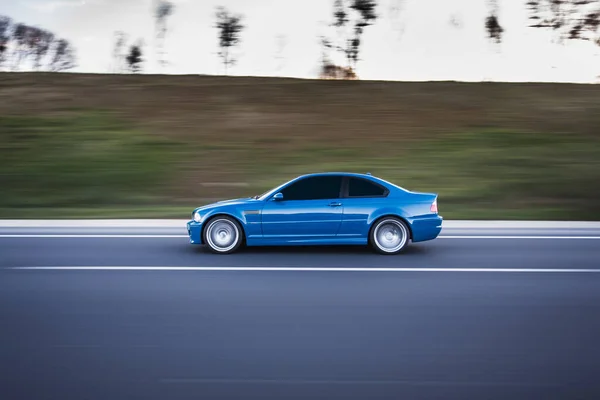 Berline bleue conduisant sur l'autoroute au crépuscule — Photo