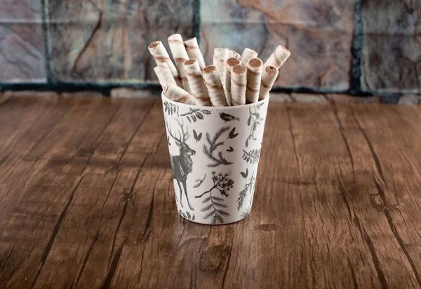 Waffle sticks in a cardboard cup on a wooden table. — Stock Photo, Image