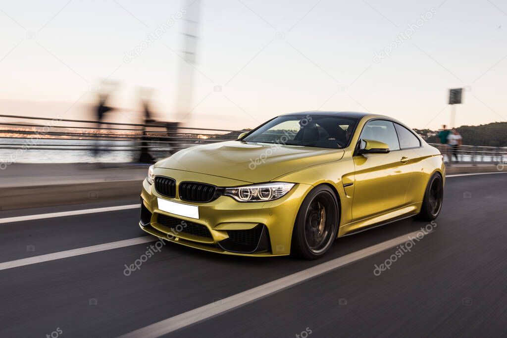 Golden sport sedan car front view on the autobahn