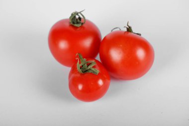 Yeşil yapraklı beyaz arkaplanda domatesler. Üst görünüm