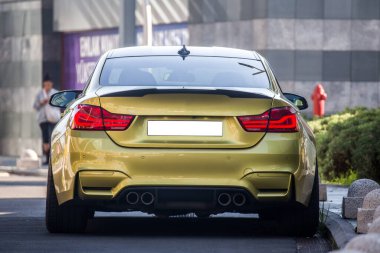 Kırmızı ksenon ışıkları olan altın renkli sedan araba arka görünümü