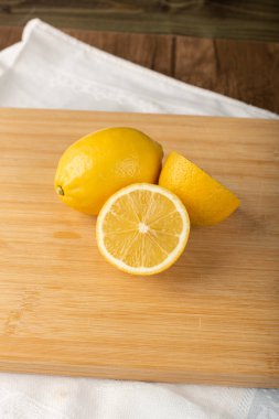 Tahtada yarısı kesilmiş ve limon parçaları var.
