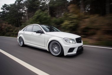 Otobanda beyaz spor sedan. Hızlı sürüş. Sol taraf ve tekerlek görünümü