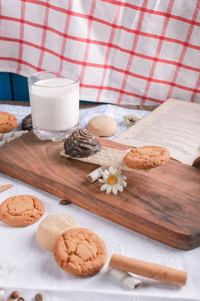 Galletas y un vaso de leche en una tabla de cortar — Foto de Stock