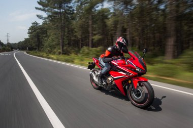Motosikletli ve kasklı bir motosikletli.