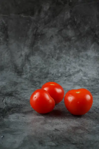 Tomates frescos vermelhos em um fundo de pedra . — Fotografia de Stock