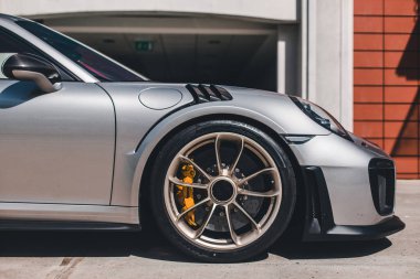 Gümüş bir arabanın ön ışığı ve tekerleği.