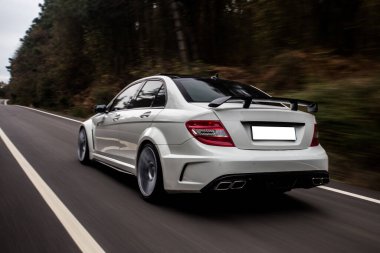 Otobanda Whitesport Sedan, doğada araba sürüyor.