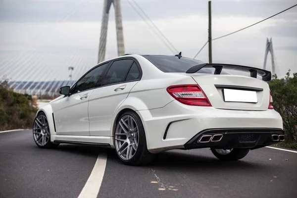 White business class sedan parking in the middle of the road. Backside view — Stock Photo, Image