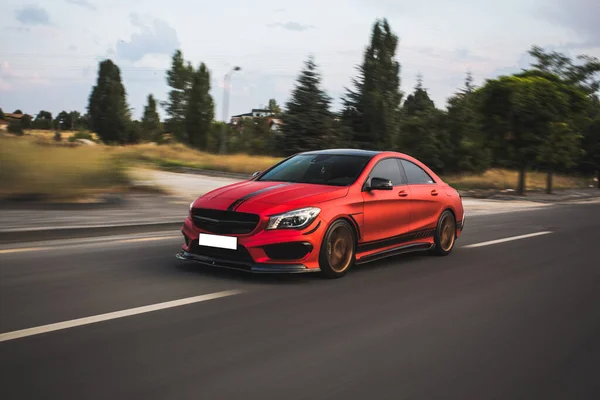 Red sport sedan driving in the nature — Stock Photo, Image