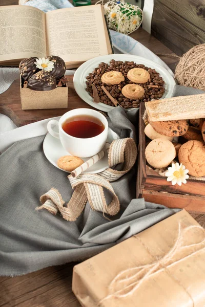 Una taza de té, pralinés de chocolate y una bandeja de galletas — Foto de Stock
