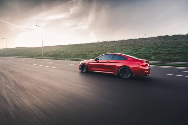 Rode luxe sedan rijden in de schemering tijd — Stockfoto