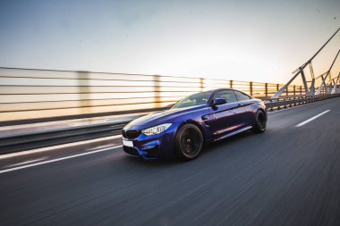 Köprüde birinci sınıf siyah bir sedan sürüyor. Profil görünümü