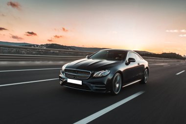 Güzel gün batımında siyah birinci sınıf bir sedan sürüyordu.