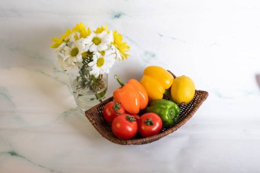 Beyaz masada domates ve çan pepleri var.