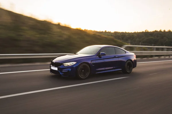 Siyah birinci sınıf sedan yolda.