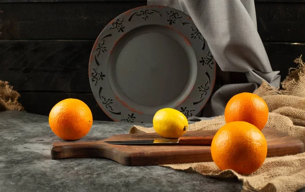 Etnik kırsal bir arka planda portakal ve limon. — Stok fotoğraf
