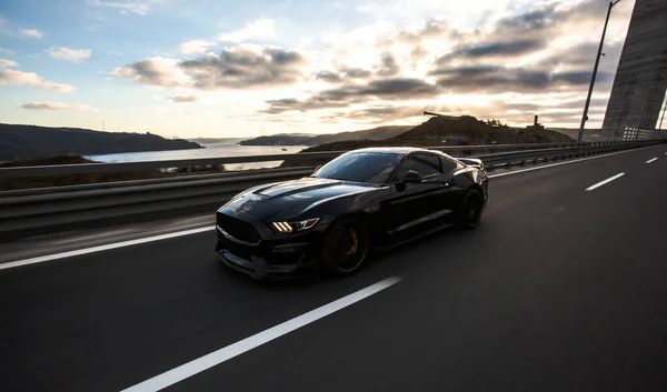 Black sport car driving on the road, front view — Stock Photo, Image