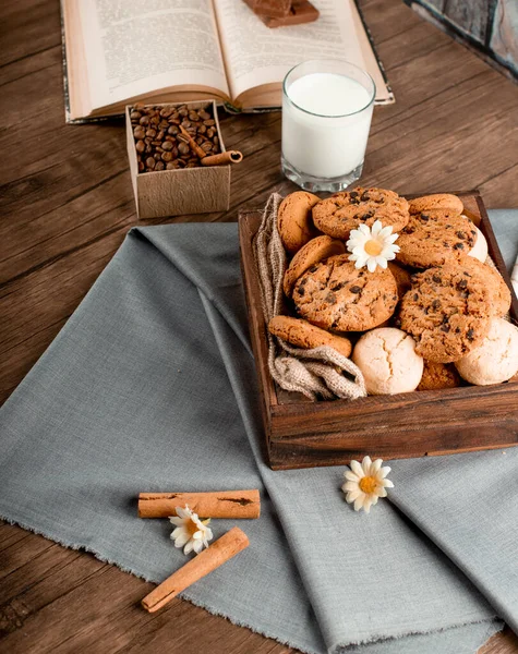 Palitos de canela y una caja de galletas en un mantel azul — Foto de Stock