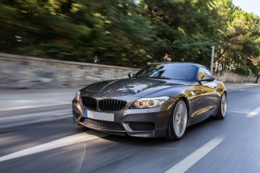 Şehrin sokaklarında gri spor arabaları, ön manzara.