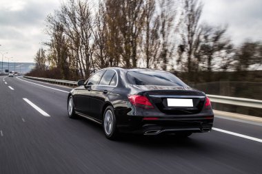 Siyah spor araba kış vakti yolda.