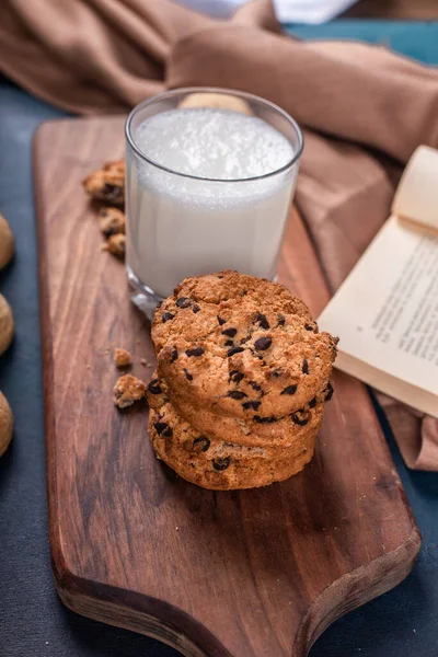 Un vaso de leche con galletas dulces en una tabla de madera — Foto de Stock