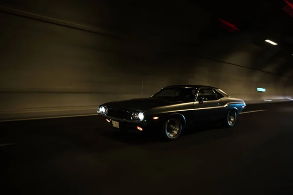 暗いトンネルで黒いセダンの運転。前照灯 — ストック写真