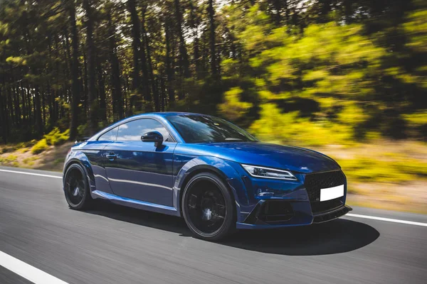 Azul luxo sedan coupe carro na estrada na floresta — Fotografia de Stock