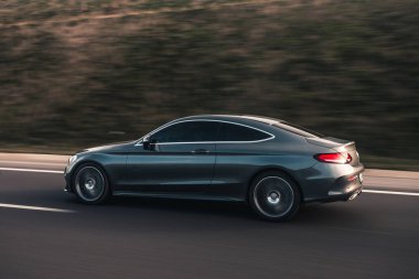 Yollarda gümüş renkli lüks bir sedan.