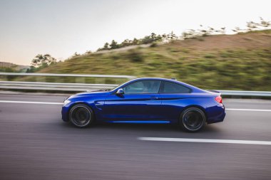 Mavi birinci sınıf sedan yolda. profil görünümü