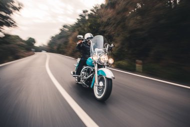 Yolda mavi bir motosiklet sürüyordu. ön görünüm