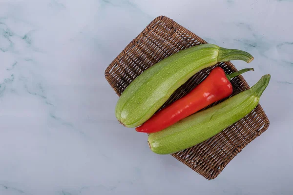 Zelená cuketa a červené chilli na modré — Stock fotografie