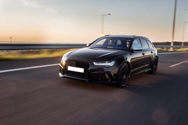 Alacakaranlıkta yolda siyah SUV yüksek hız sürücüsü