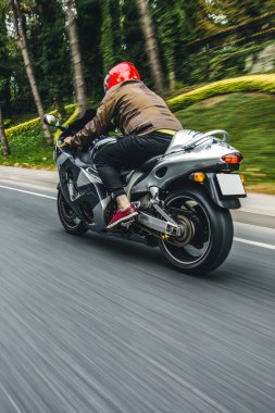 Motosikletli kırmızı kasklı bir motorcu. arka plan