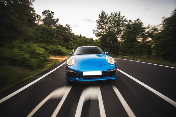 森の中の青いスポーツカー高速ドライブ — ストック写真
