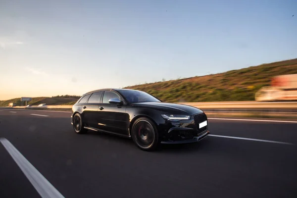 Hatchback preto dirigindo através das colinas durante o dia — Fotografia de Stock