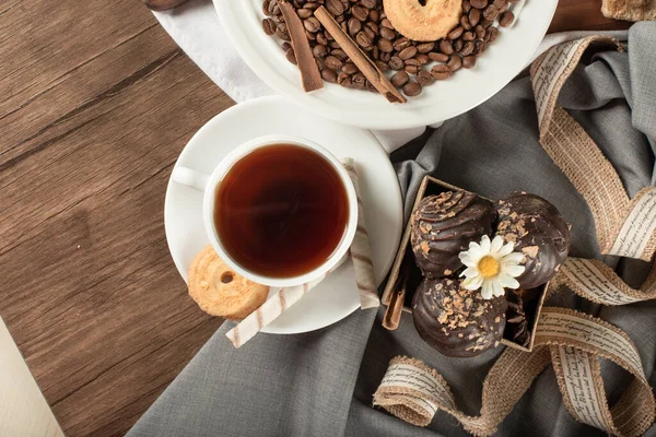 Шоколадные пралине и печенье в блюдце с чашкой чая — стоковое фото