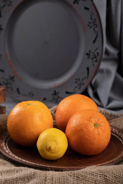 オレンジとレモンの後ろにダークプラッタ. — ストック写真