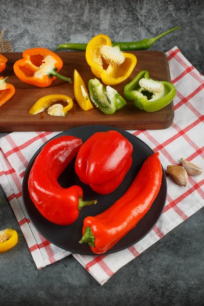 Mixed bell peppers on a white checked towel. Top view. — Stock Photo, Image