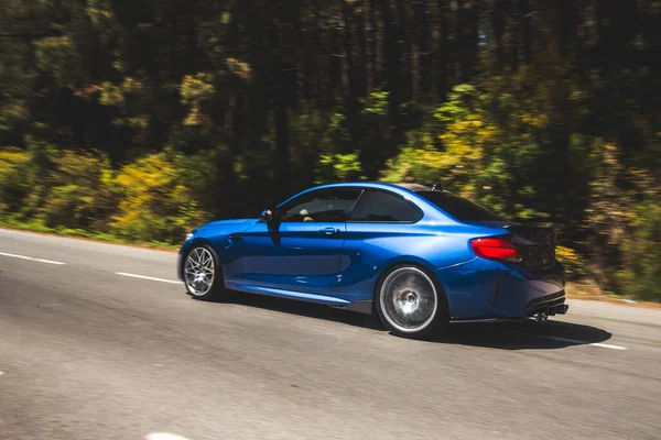 Blue sport coupe pe pe drumul forestier — Fotografie, imagine de stoc